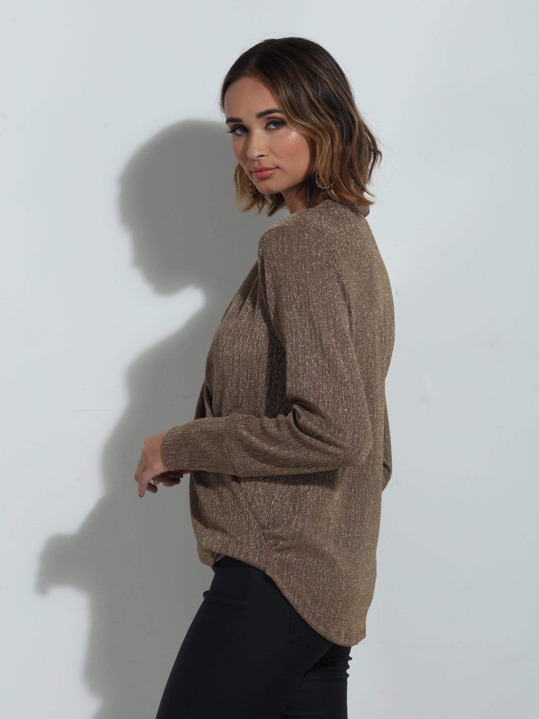 side angle of brown sparkle long sleeve blouse on woman in black pants