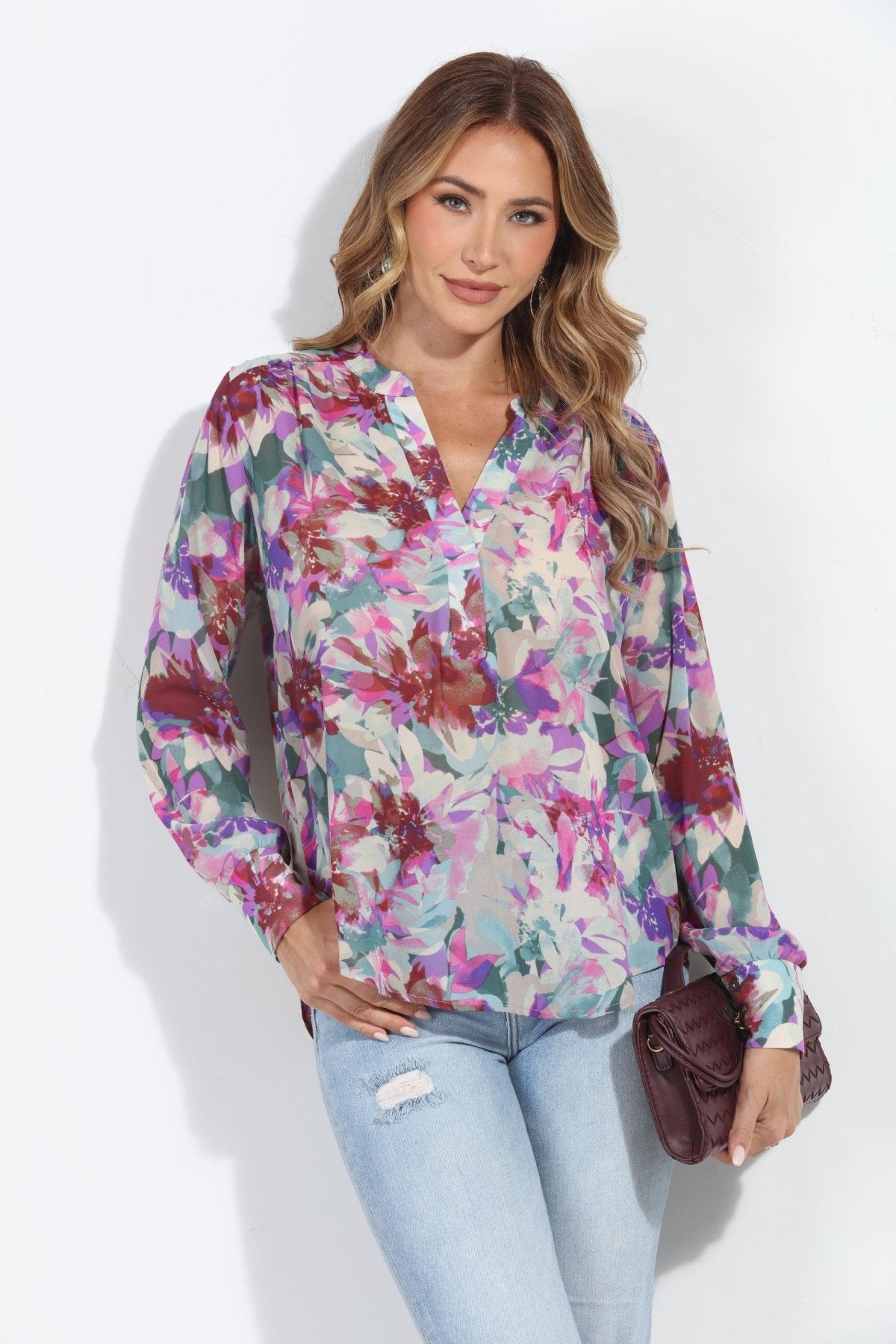floral multicolored blouse on woman in jeans and holding dark purple blouse