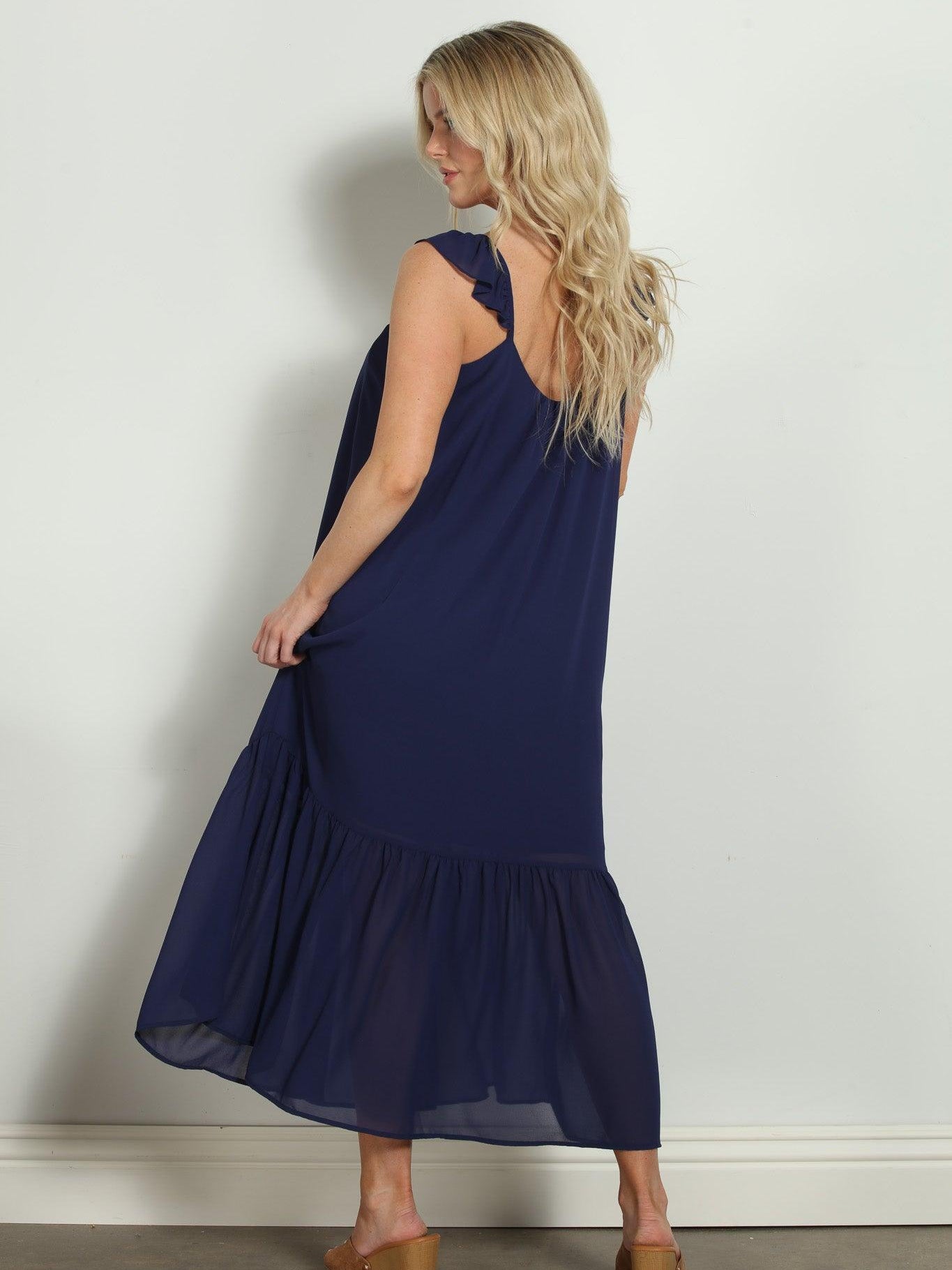 backside of woman in sleeveless navy maxi dress