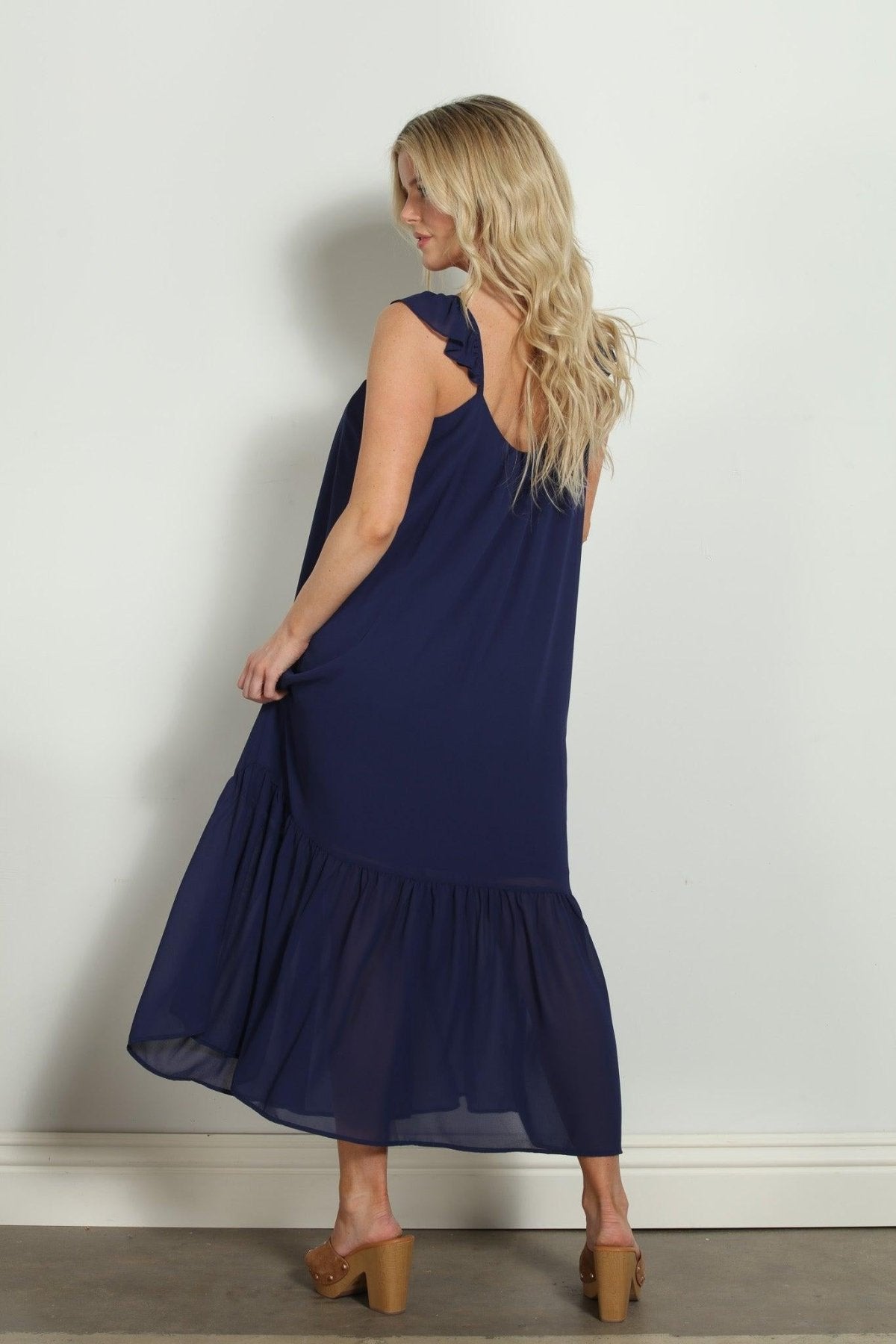 backside of woman in sleeveless navy maxi dress
