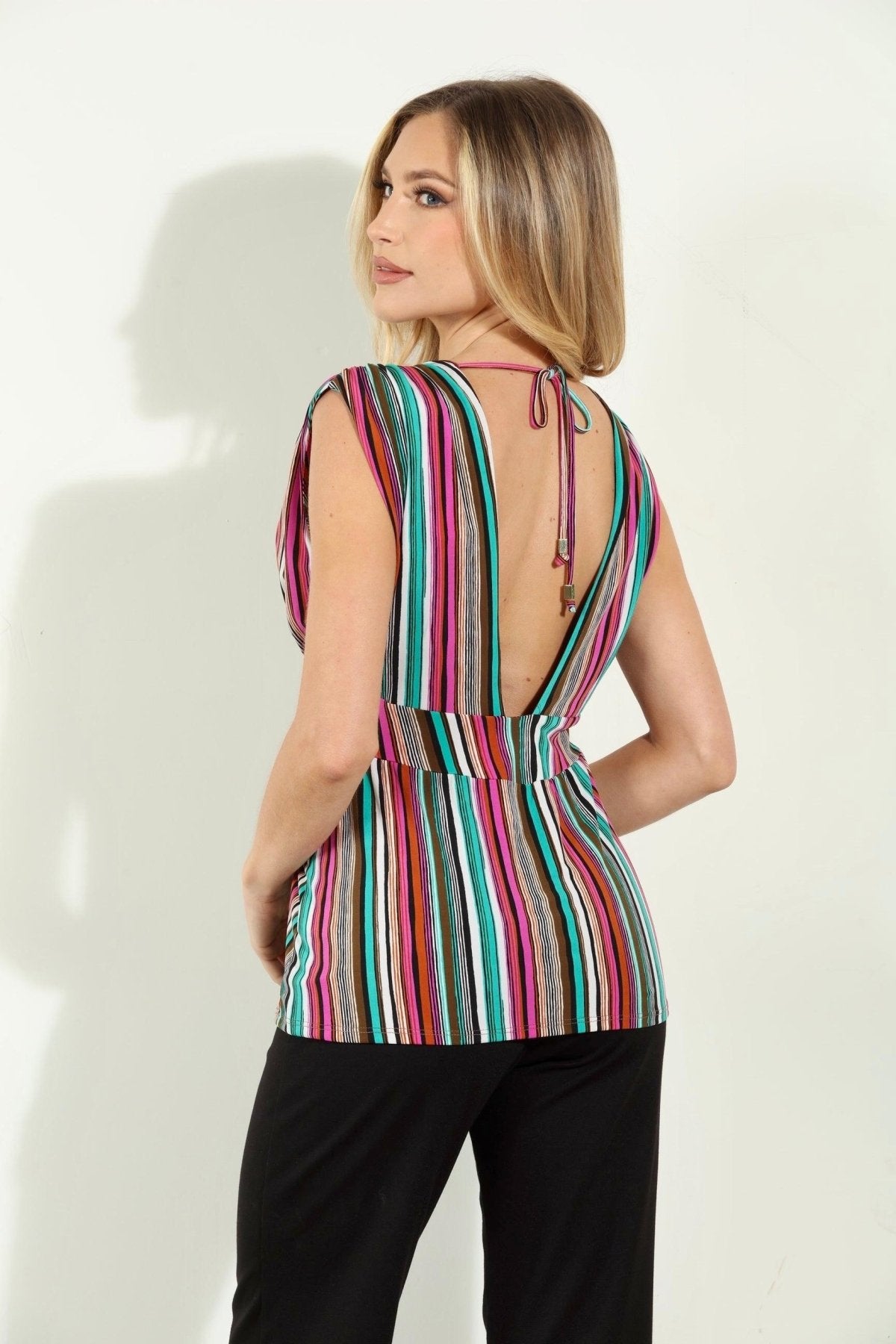 backside of woman in multicolored sleeveless blouse and black pants
