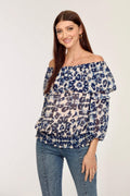 blue and white printed off the shoulder blouse on woman in denim pants