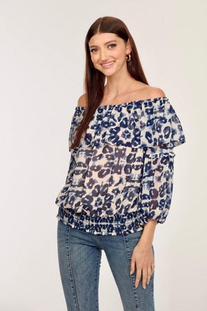 blue and white printed off the shoulder blouse on woman in denim pants