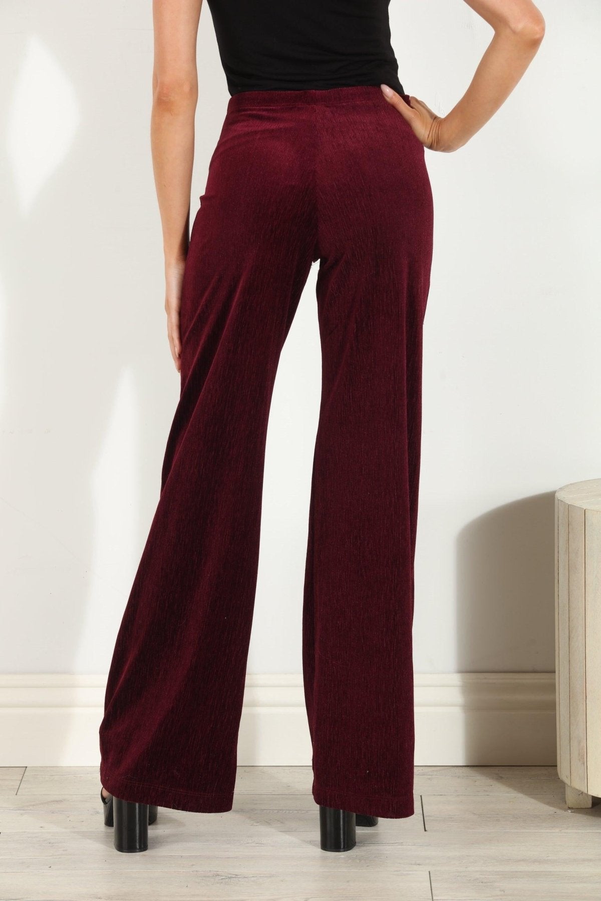 backside of woman in wine colored velvet pants
