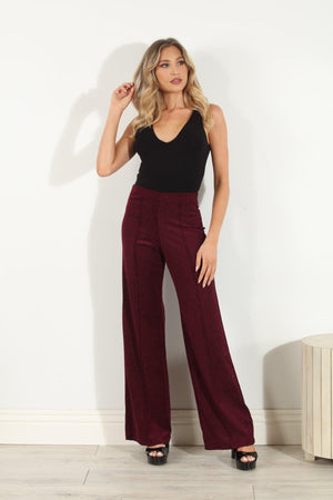 woman in black sleeveless top and wine colored velvet pants