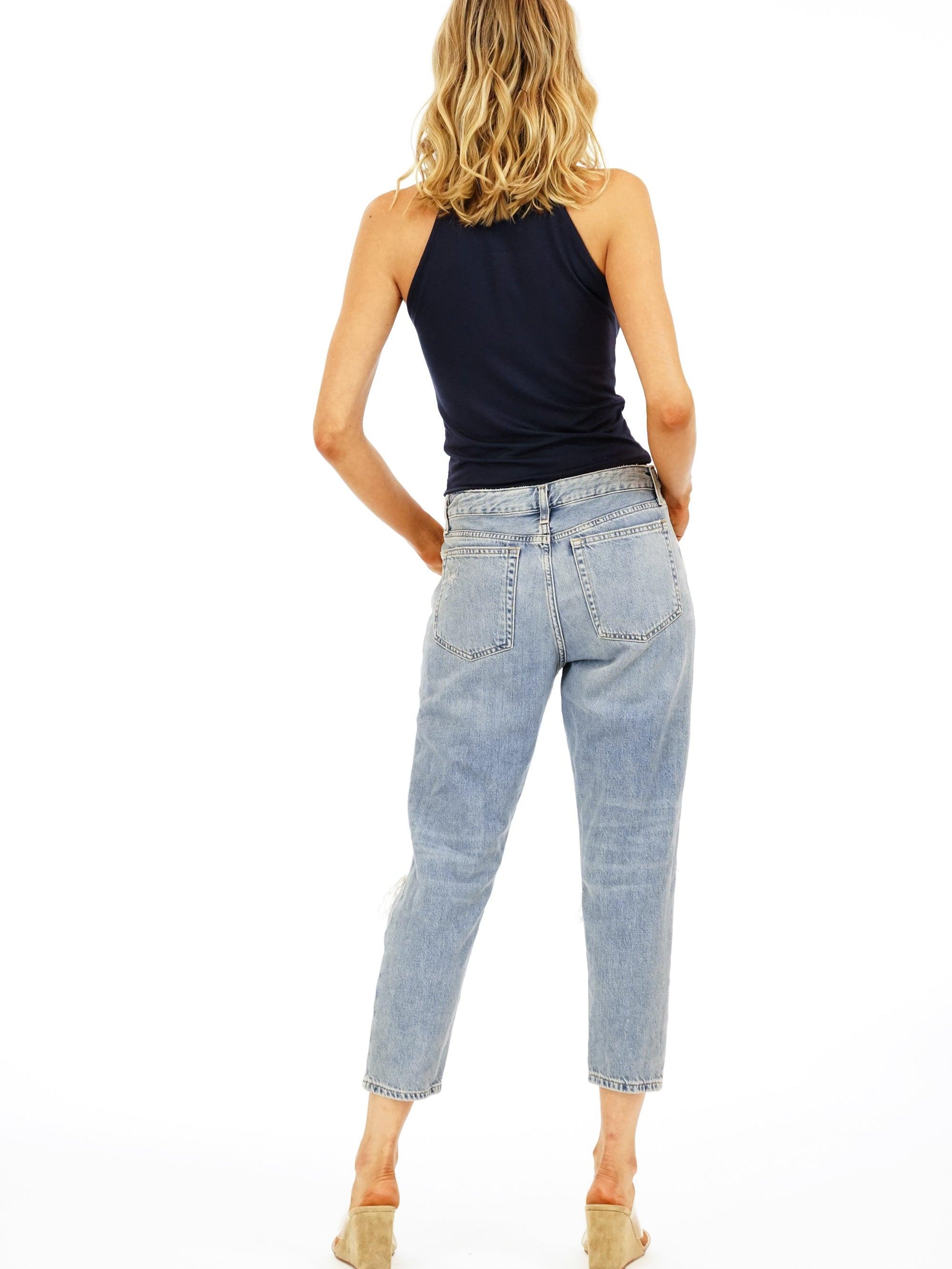backside of woman in navy sleeveless top and jeans