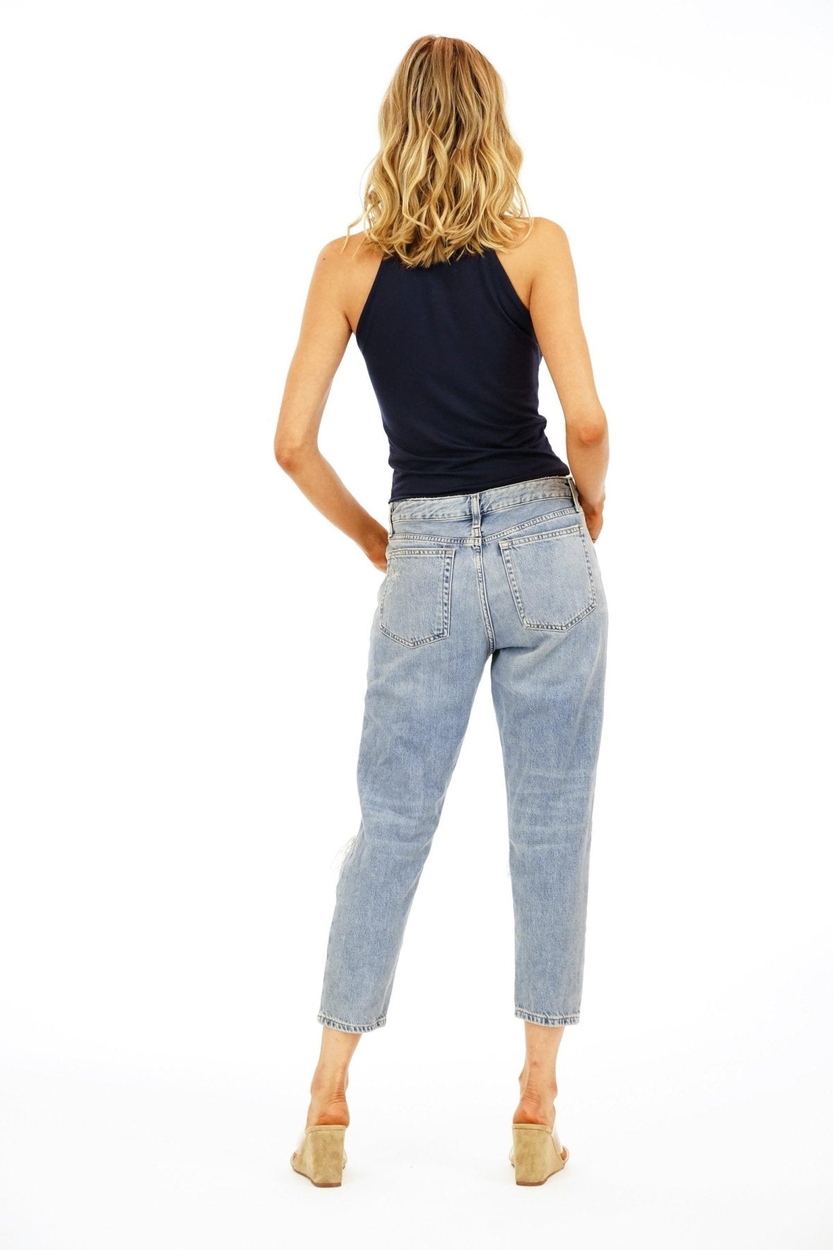 backside of woman in navy sleeveless top and jeans