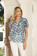 woman in printed blue short-sleeve blouse and white pants