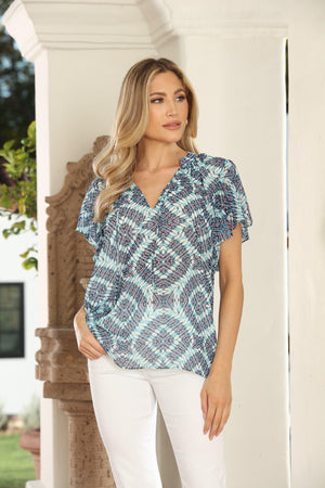 woman in printed blue short-sleeve blouse and white pants