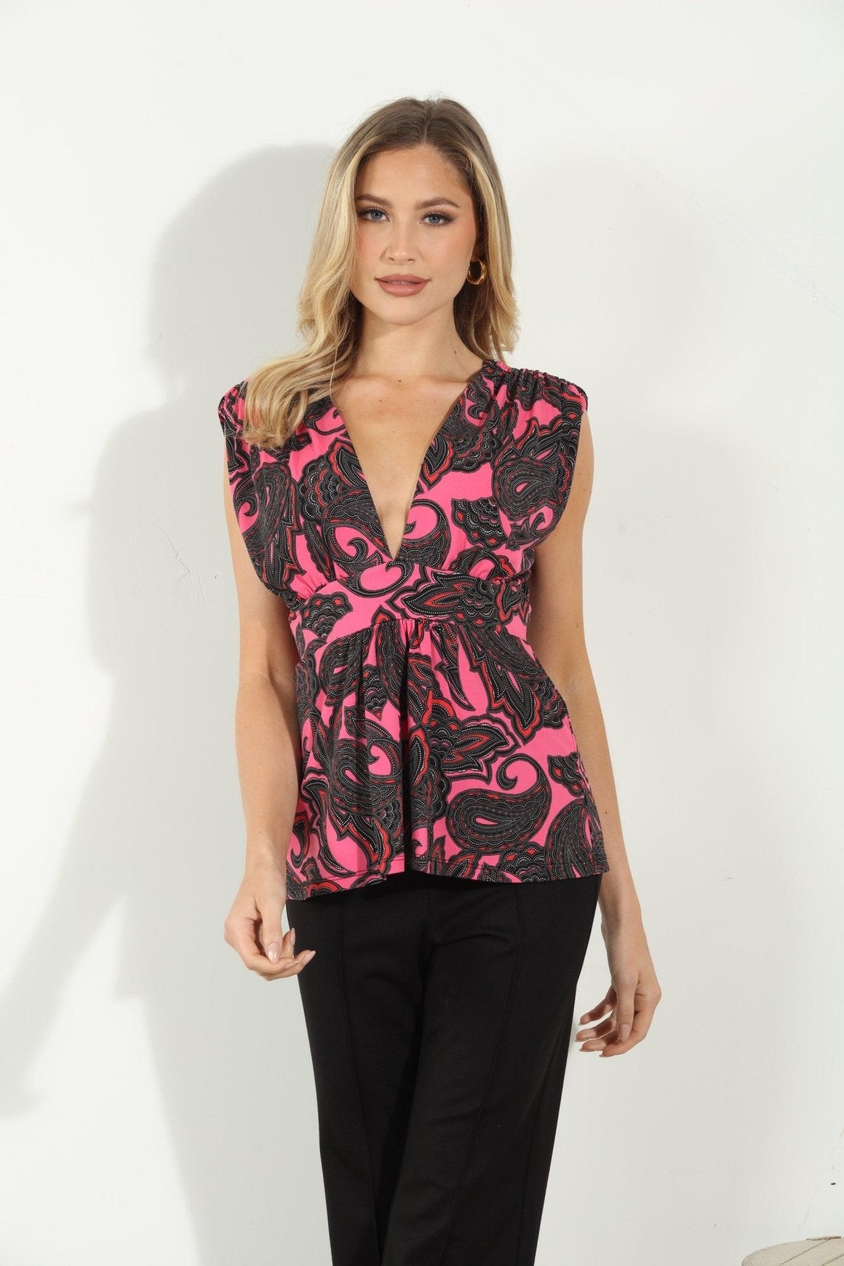 woman in pink and black sleeveless blouse and black pants