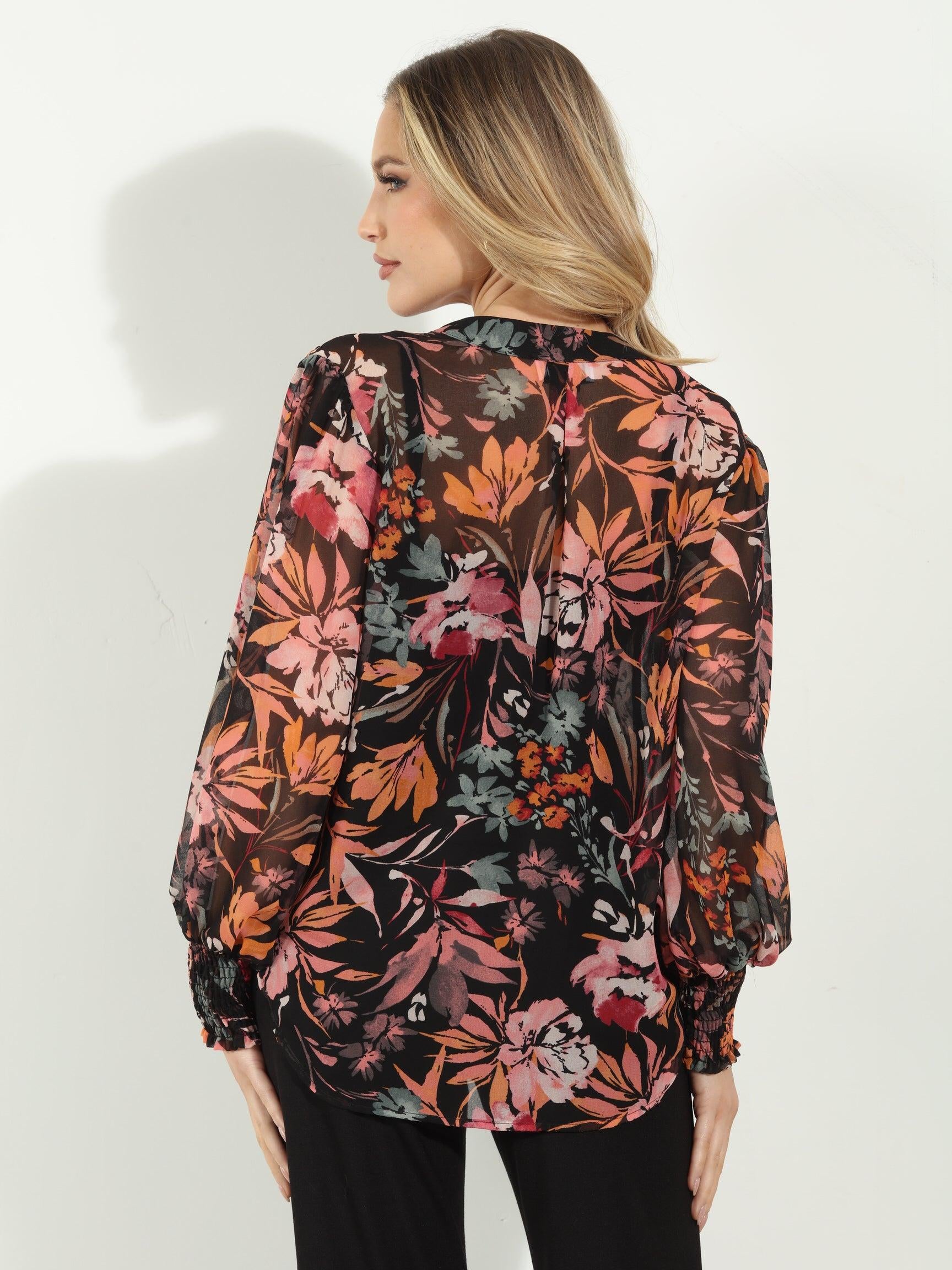 backside of multicolored long sleeve floral blouse on woman in black pants
