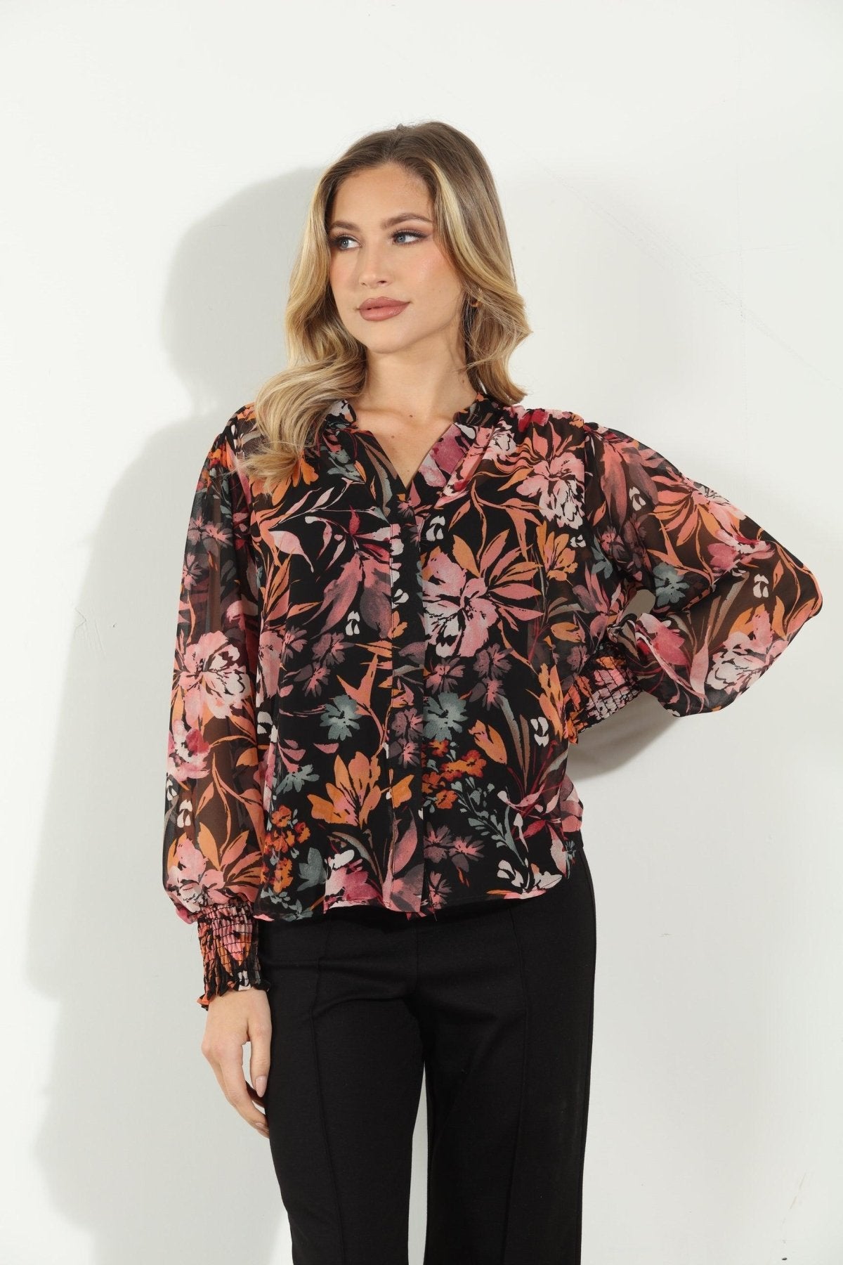 multicolored long sleeve floral blouse on woman in black pants