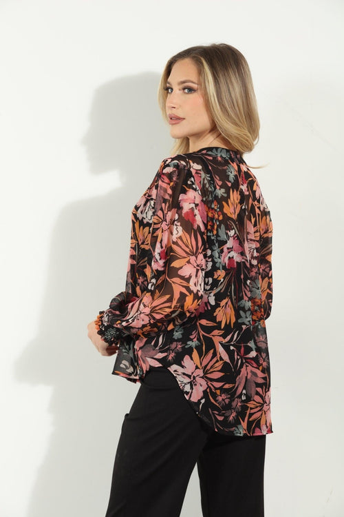 backside of multicolored long sleeve floral blouse on woman in black pants