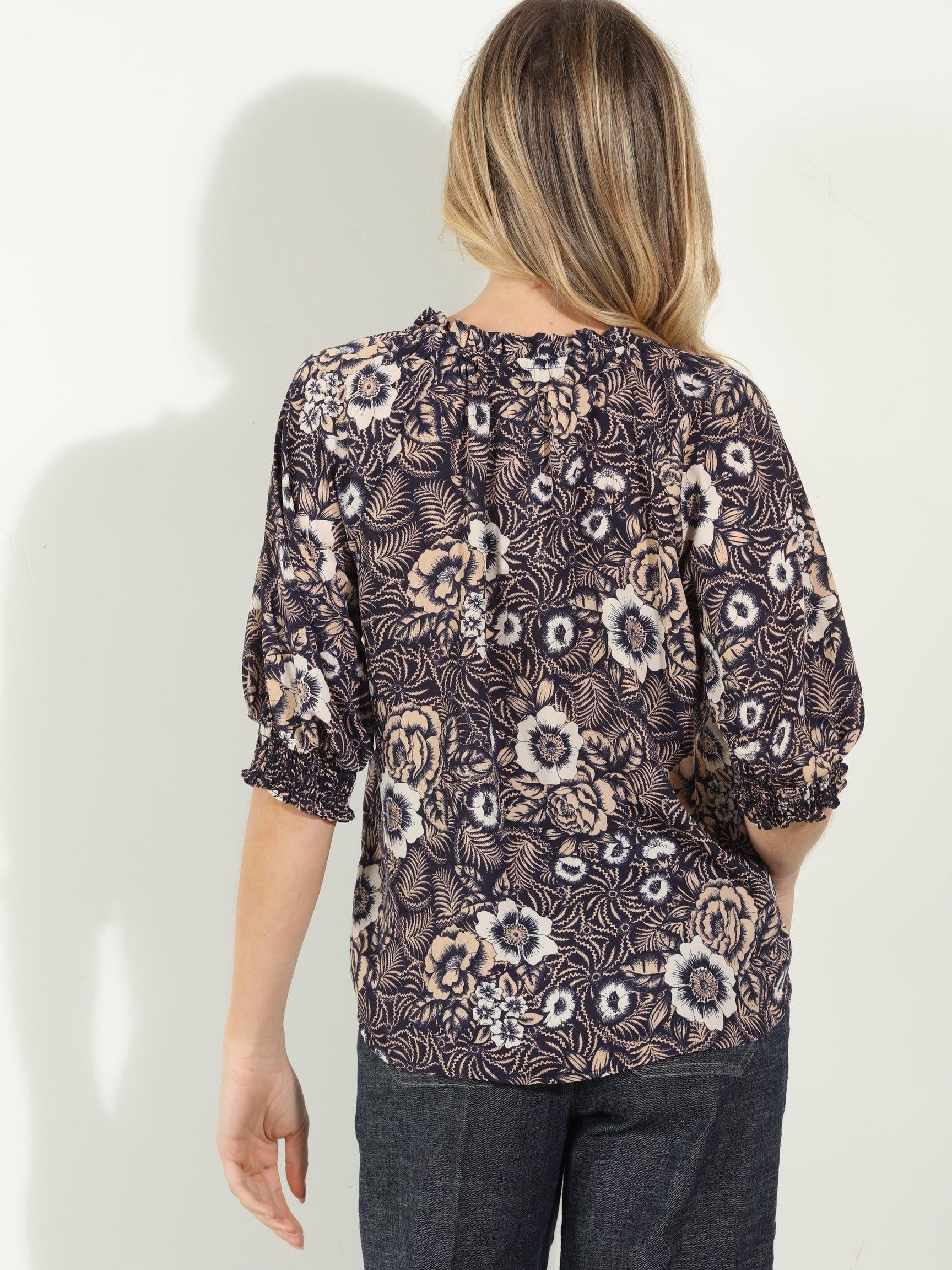 backside of woman in multicolored short sleeve blouse and denim
