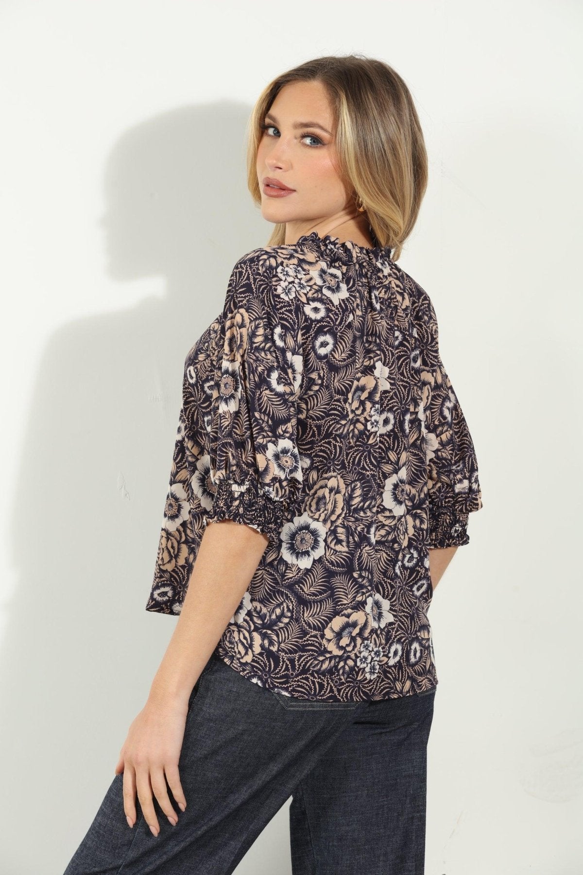backside of woman in multicolored short sleeve blouse and denim