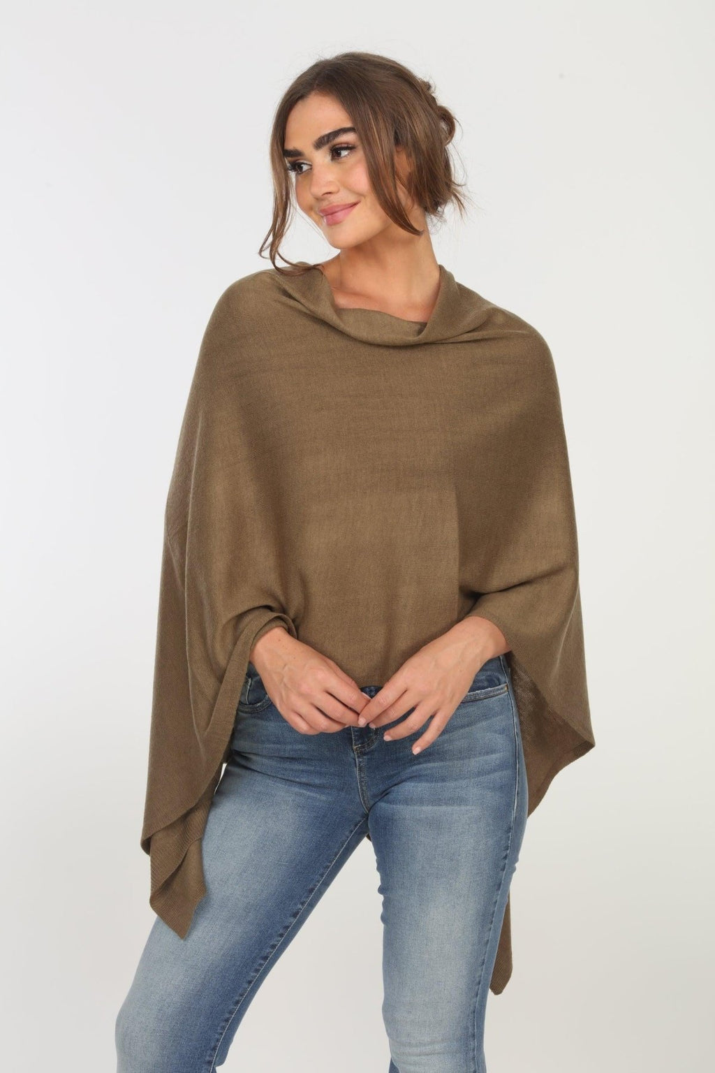 olive poncho on woman in denim pants