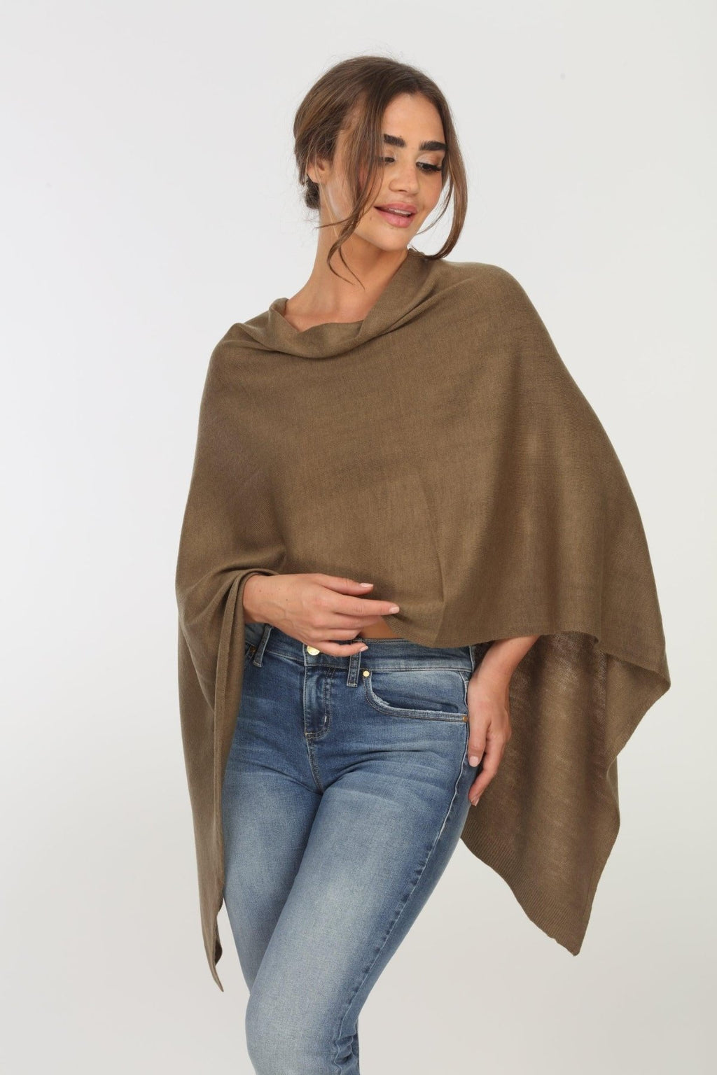 olive poncho on woman in denim pants