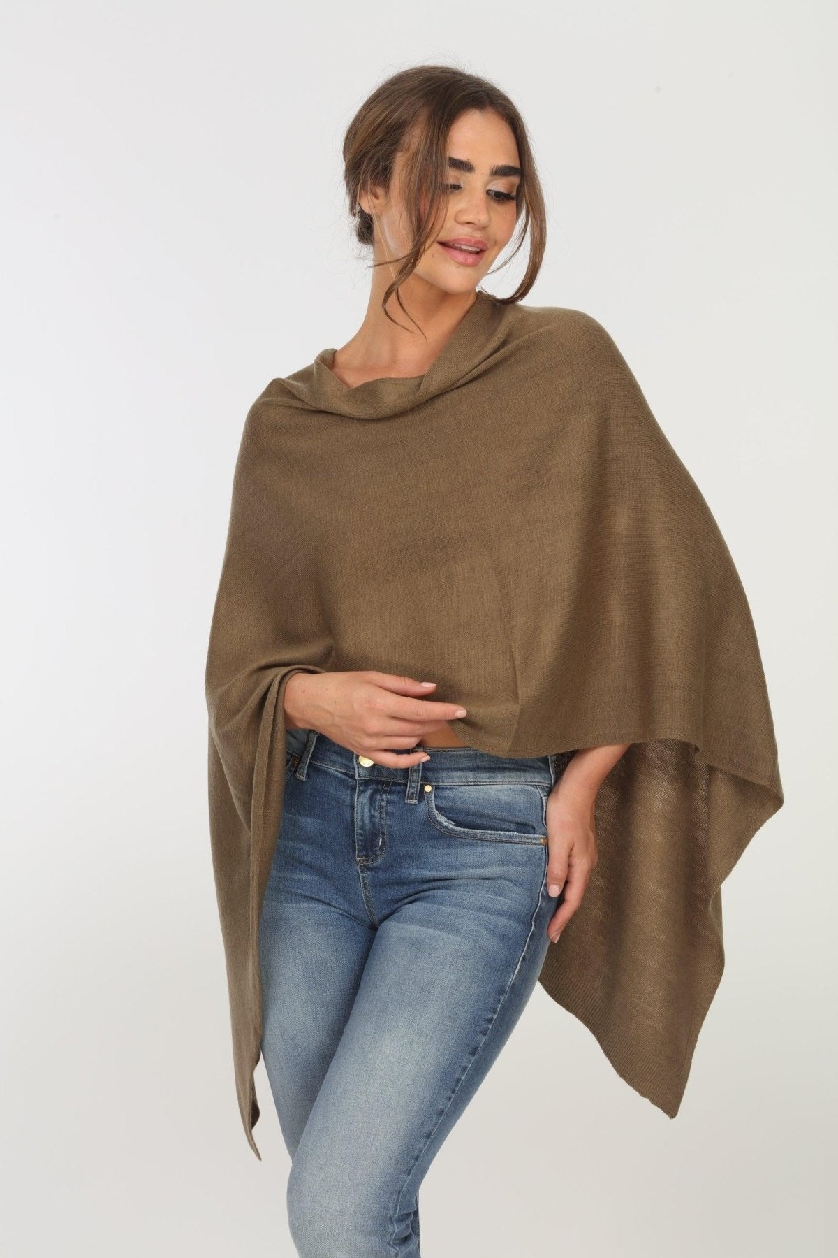 olive poncho on woman in denim pants