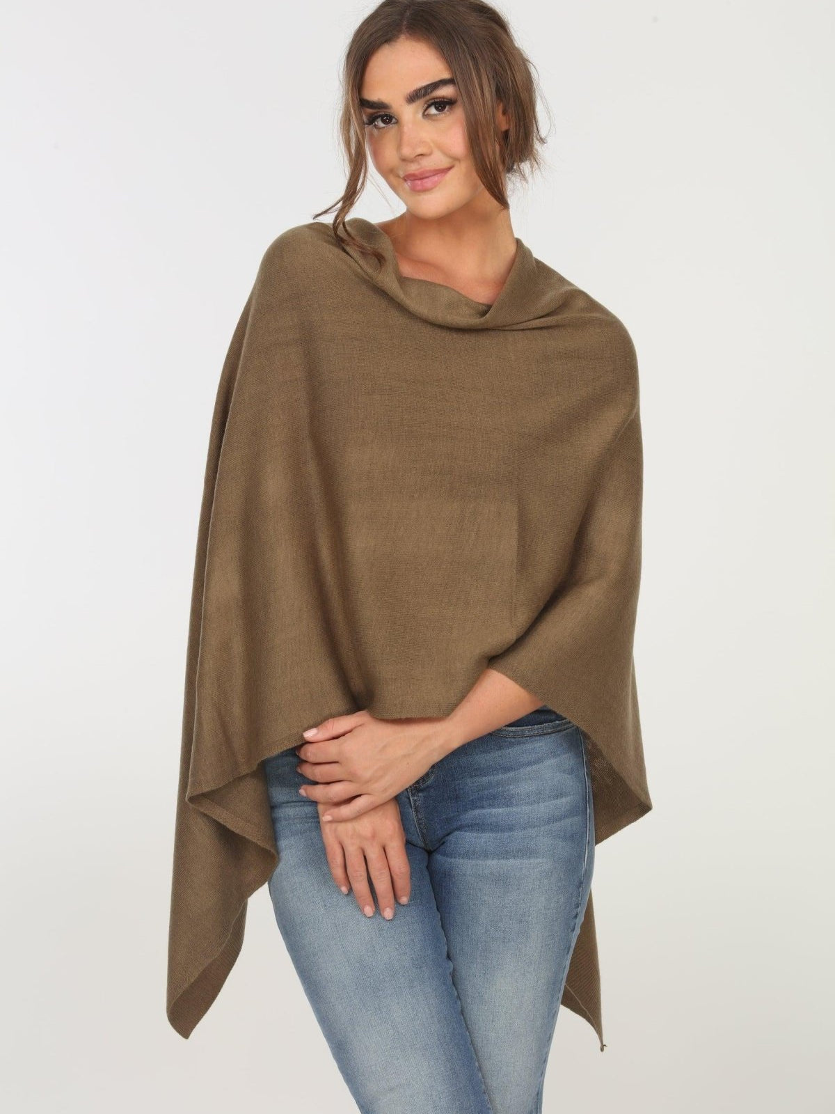 olive poncho on woman in denim pants