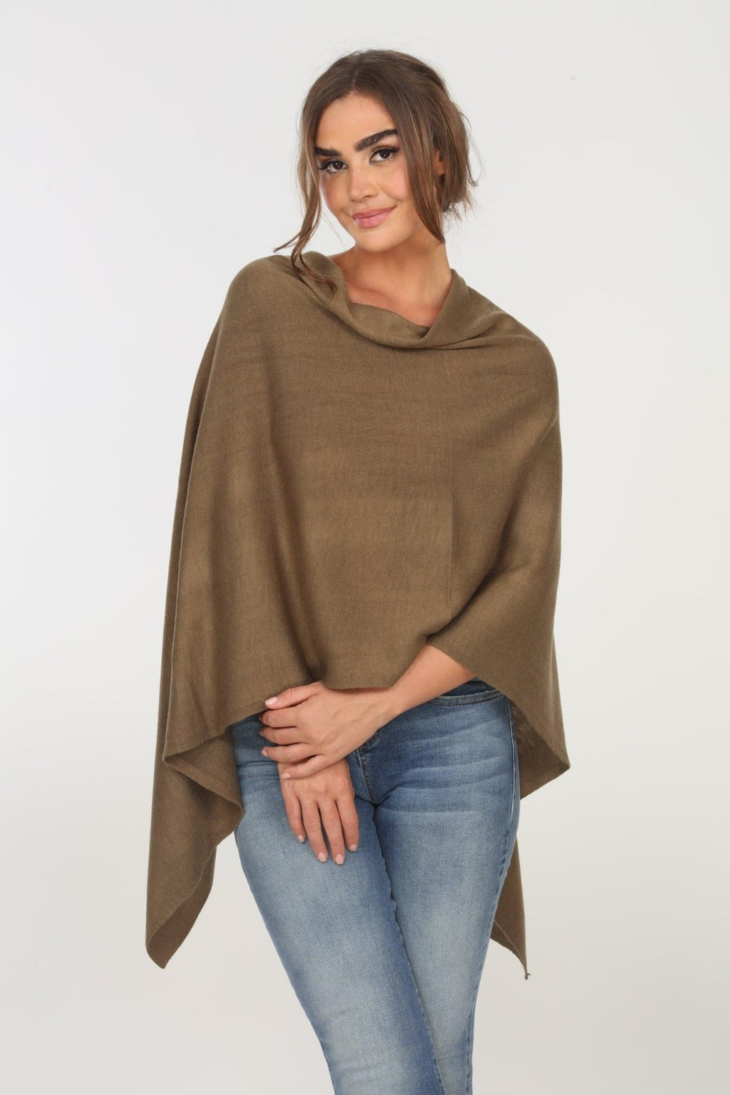olive poncho on woman in denim pants