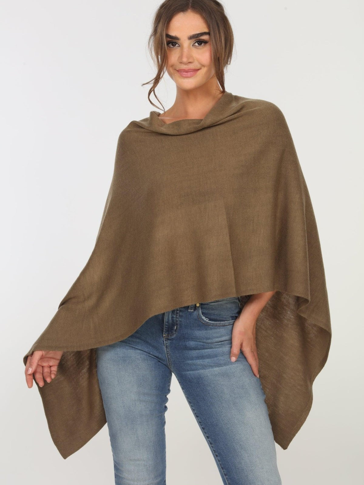 olive poncho on woman in denim pants