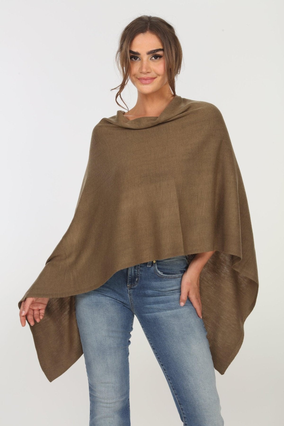 olive poncho on woman in denim pants