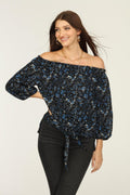black and blue off the shoulder blouse on woman in dark denim pants