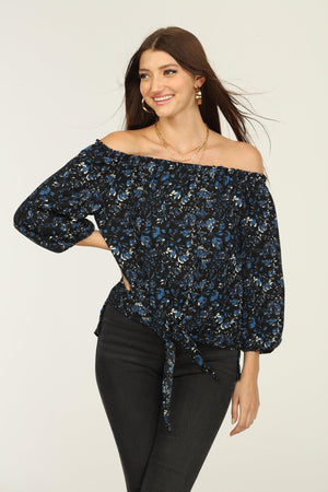 black and blue off the shoulder blouse on woman in dark denim pants