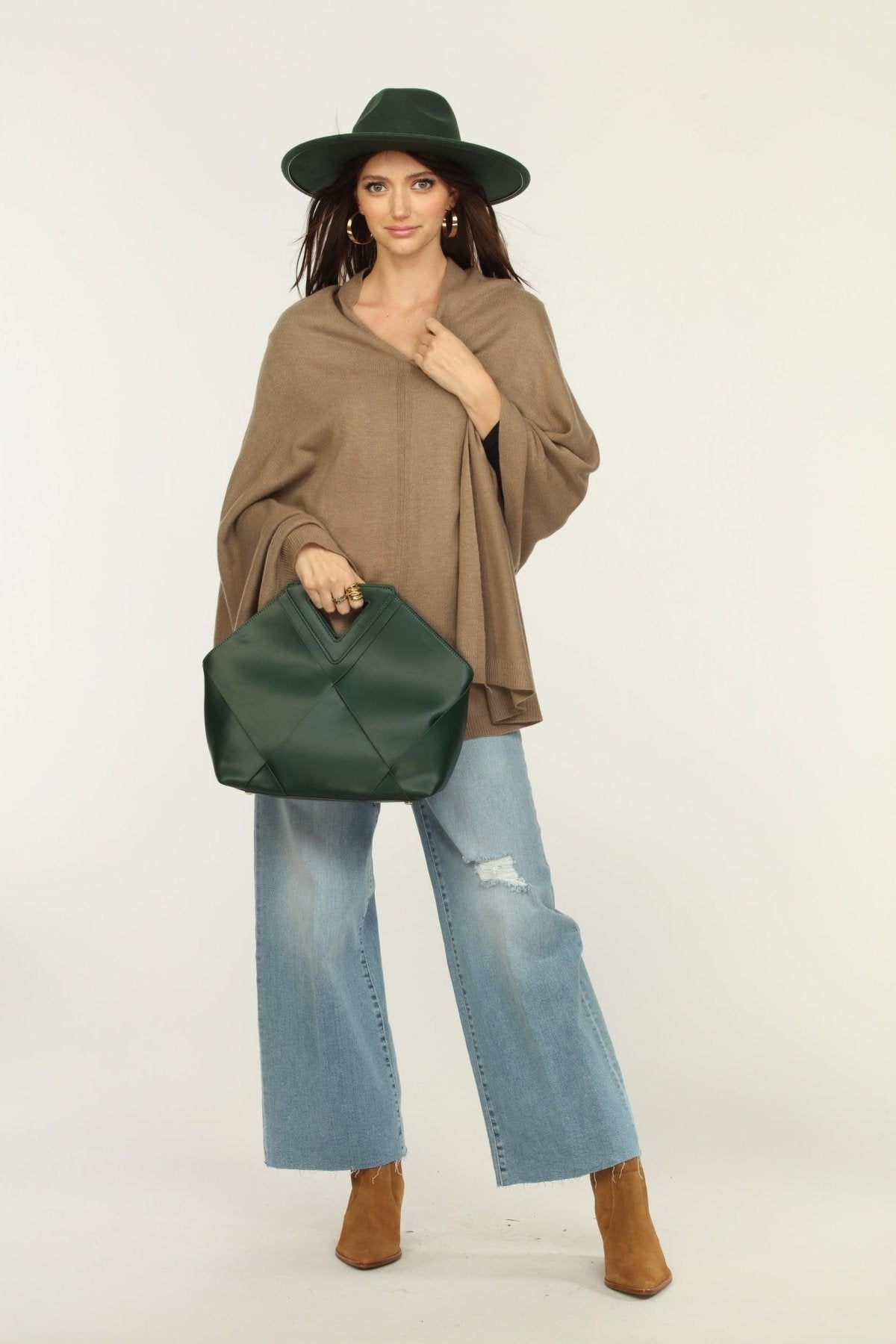 woman wearing a hat, tan poncho, jeans, and tan boots
