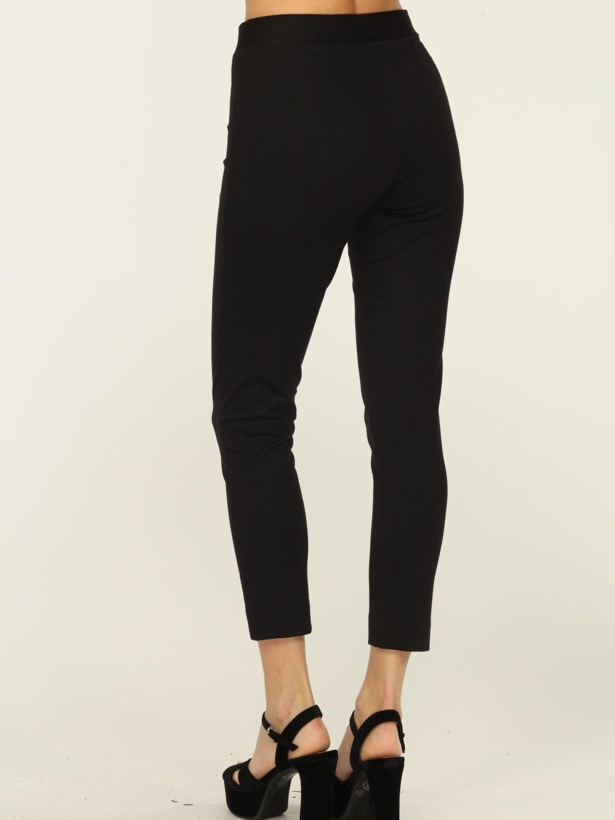 back side of black tapered pants on woman in black heels
