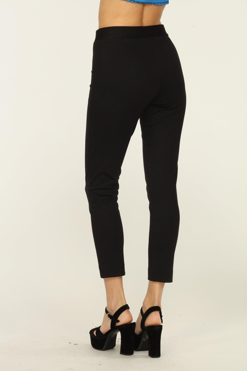back side of black tapered pants on woman in black heels