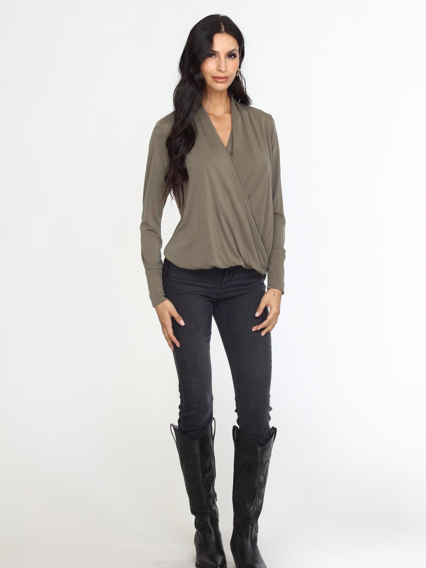 olive long sleeve draped blouse on woman in dark denim pants and black boots