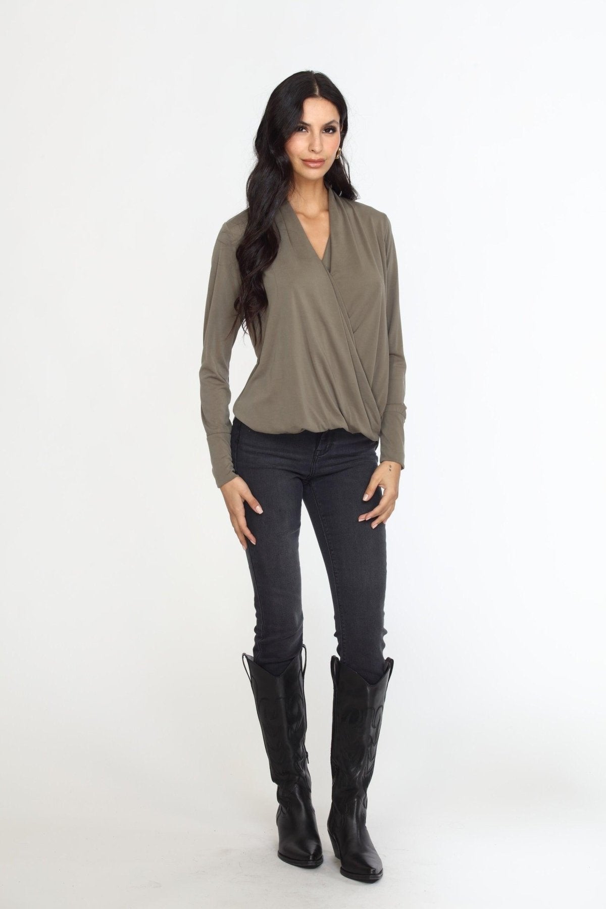 olive long sleeve draped blouse on woman in dark denim pants and black boots