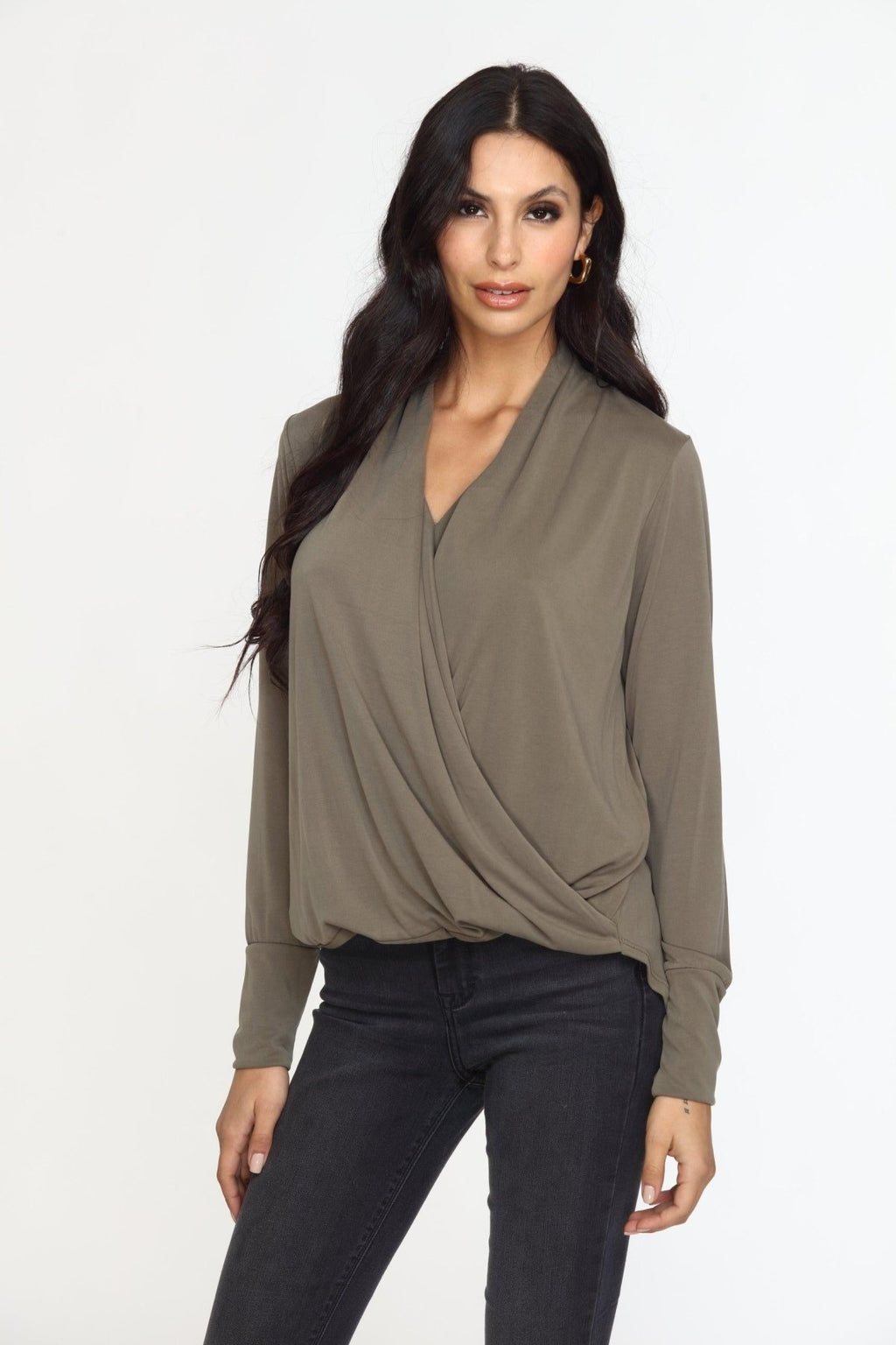olive long sleeve draped blouse on woman in dark denim pants