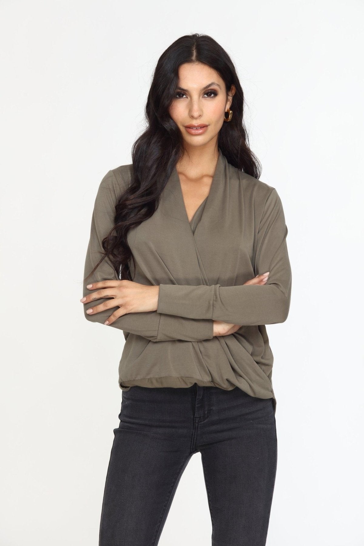 olive long sleeve draped blouse on woman in dark denim pants