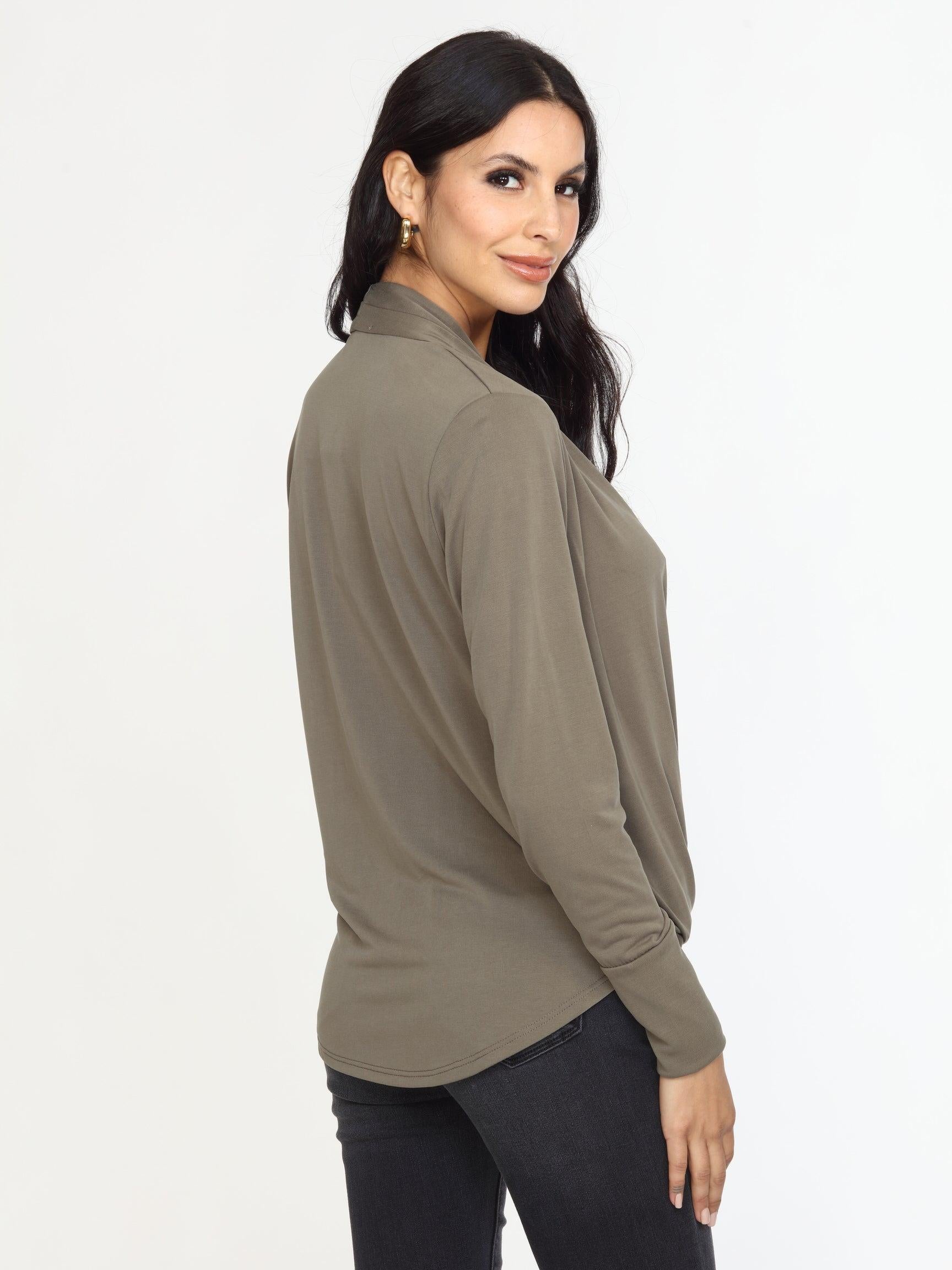 back side of olive long sleeve draped blouse on woman in dark denim pants