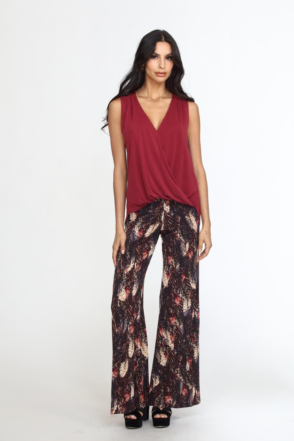 sleeveless burgundy top on woman in multicolored pants