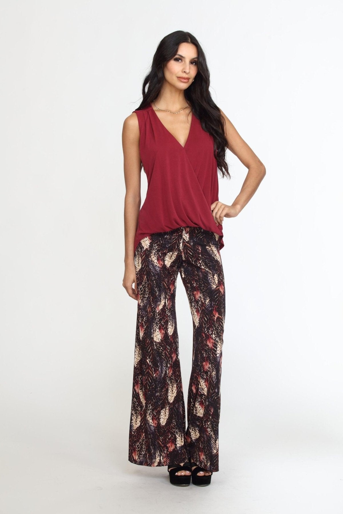 sleeveless burgundy top on woman in multicolored pants
