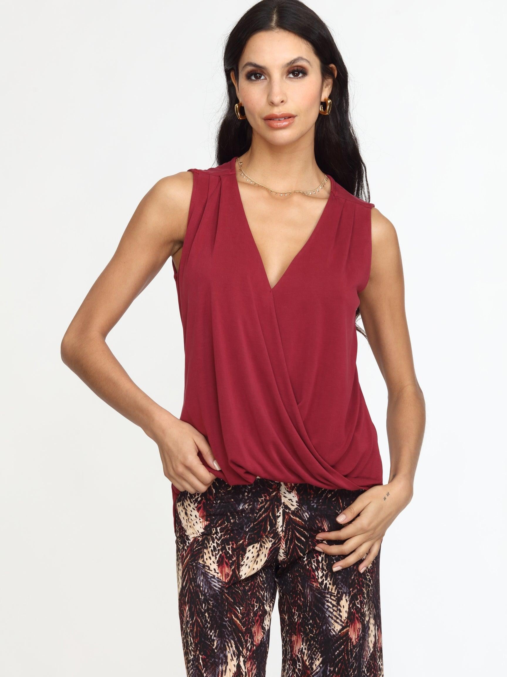 sleeveless burgundy top on woman in multicolored pants