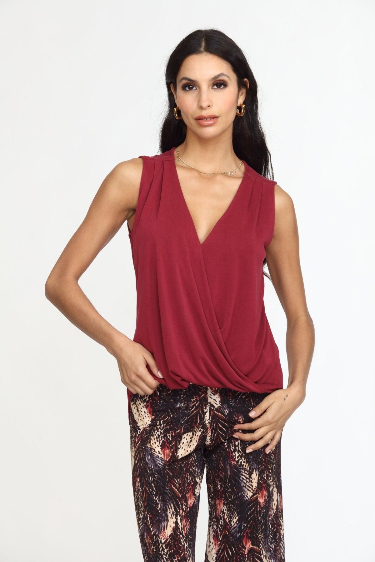 sleeveless burgundy top on woman in multicolored pants