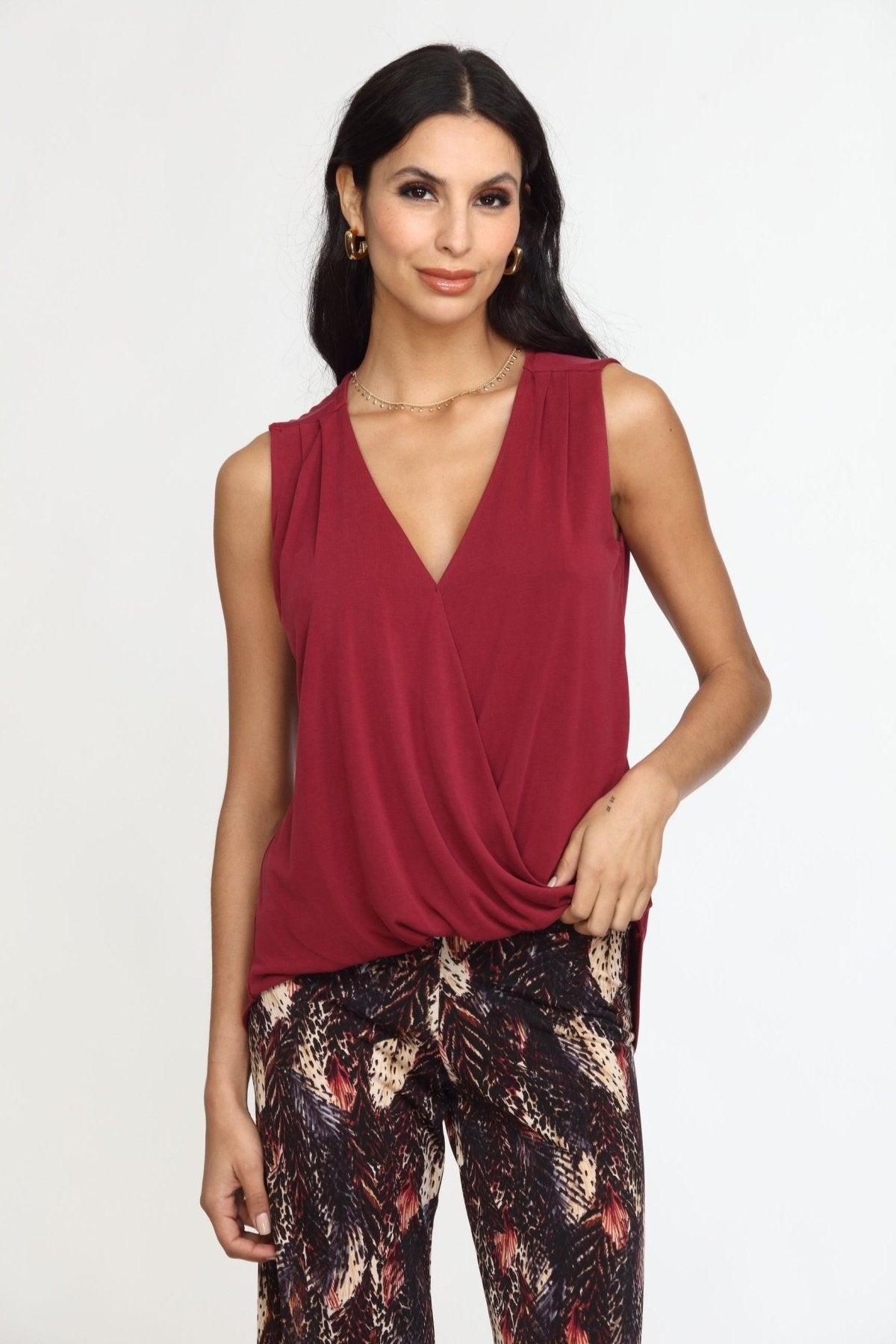 sleeveless burgundy top on woman in multicolored pants