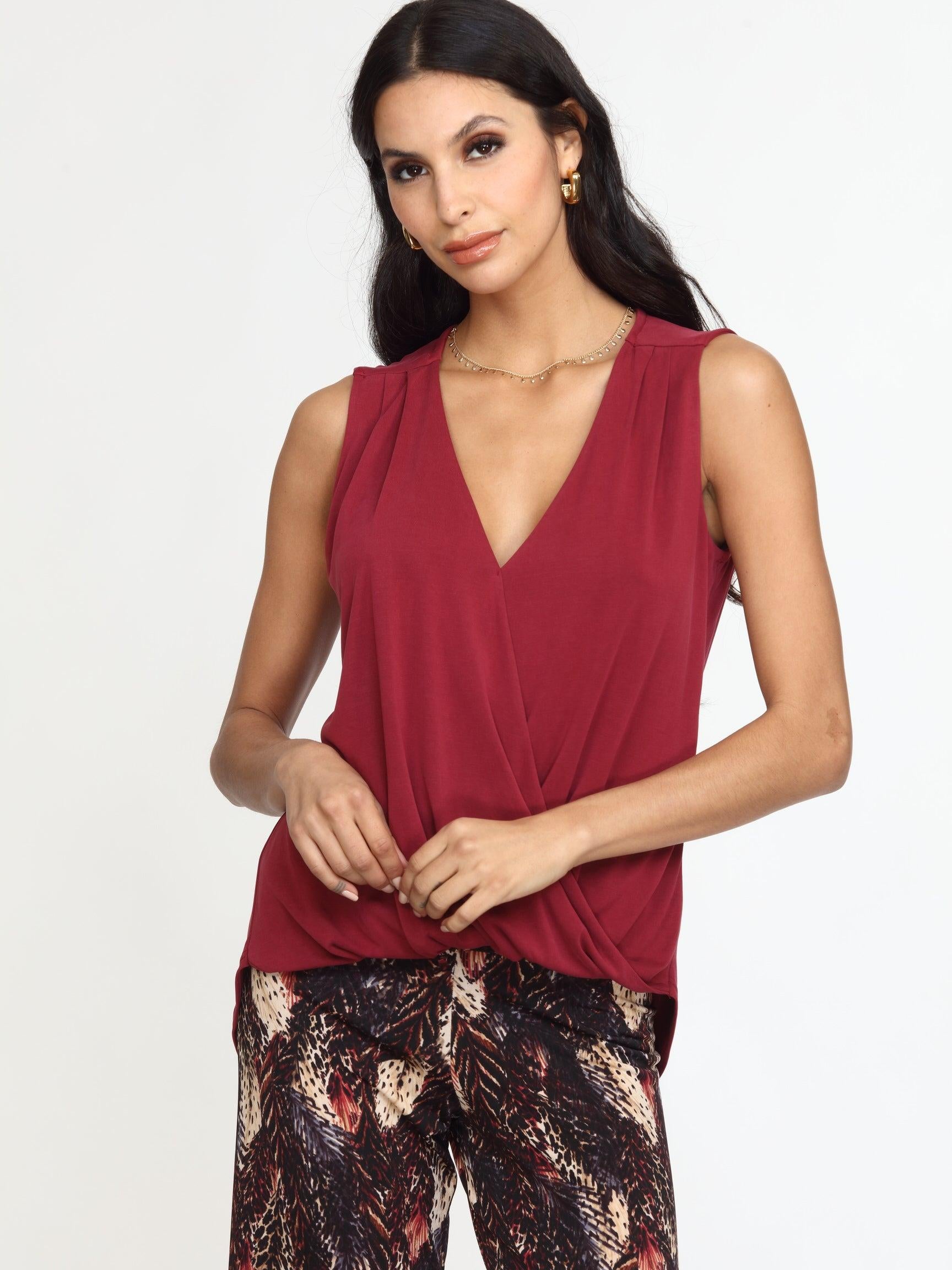 sleeveless burgundy top on woman in multicolored pants