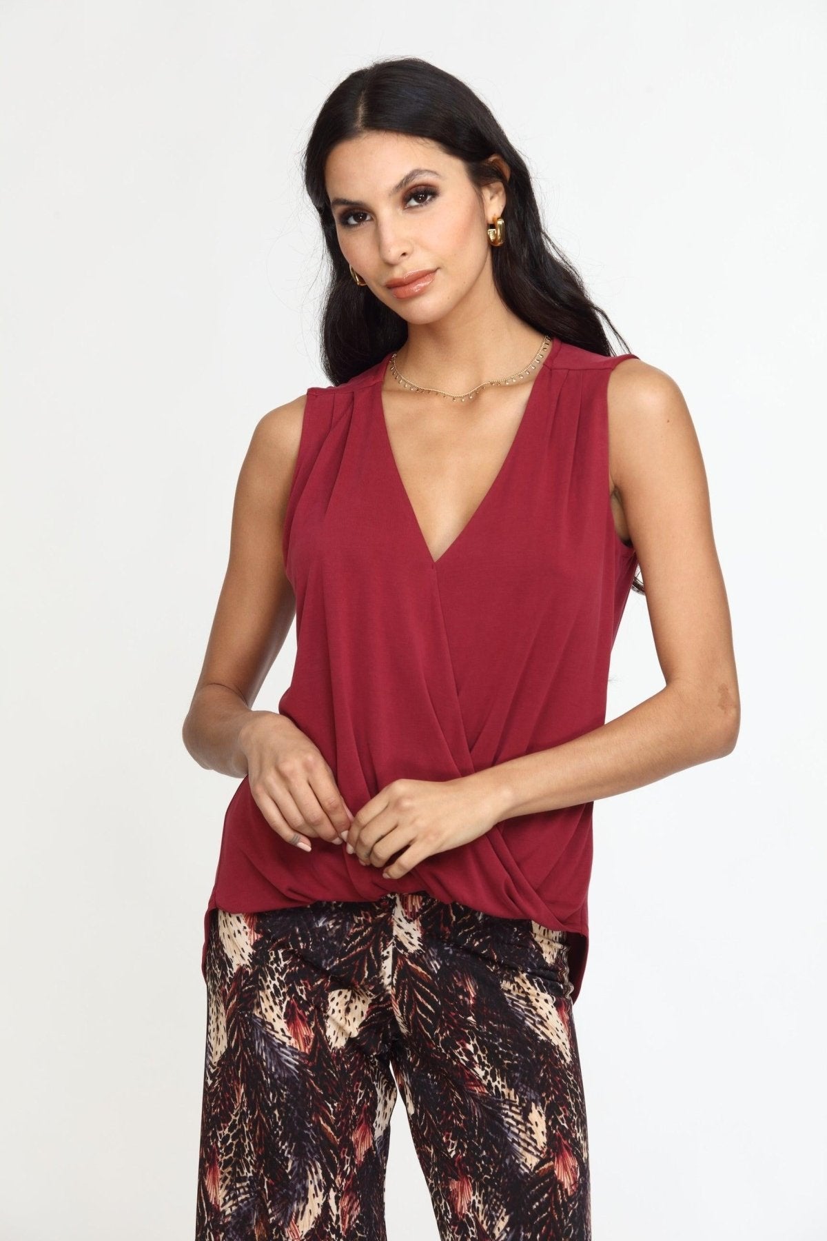 sleeveless burgundy top on woman in multicolored pants