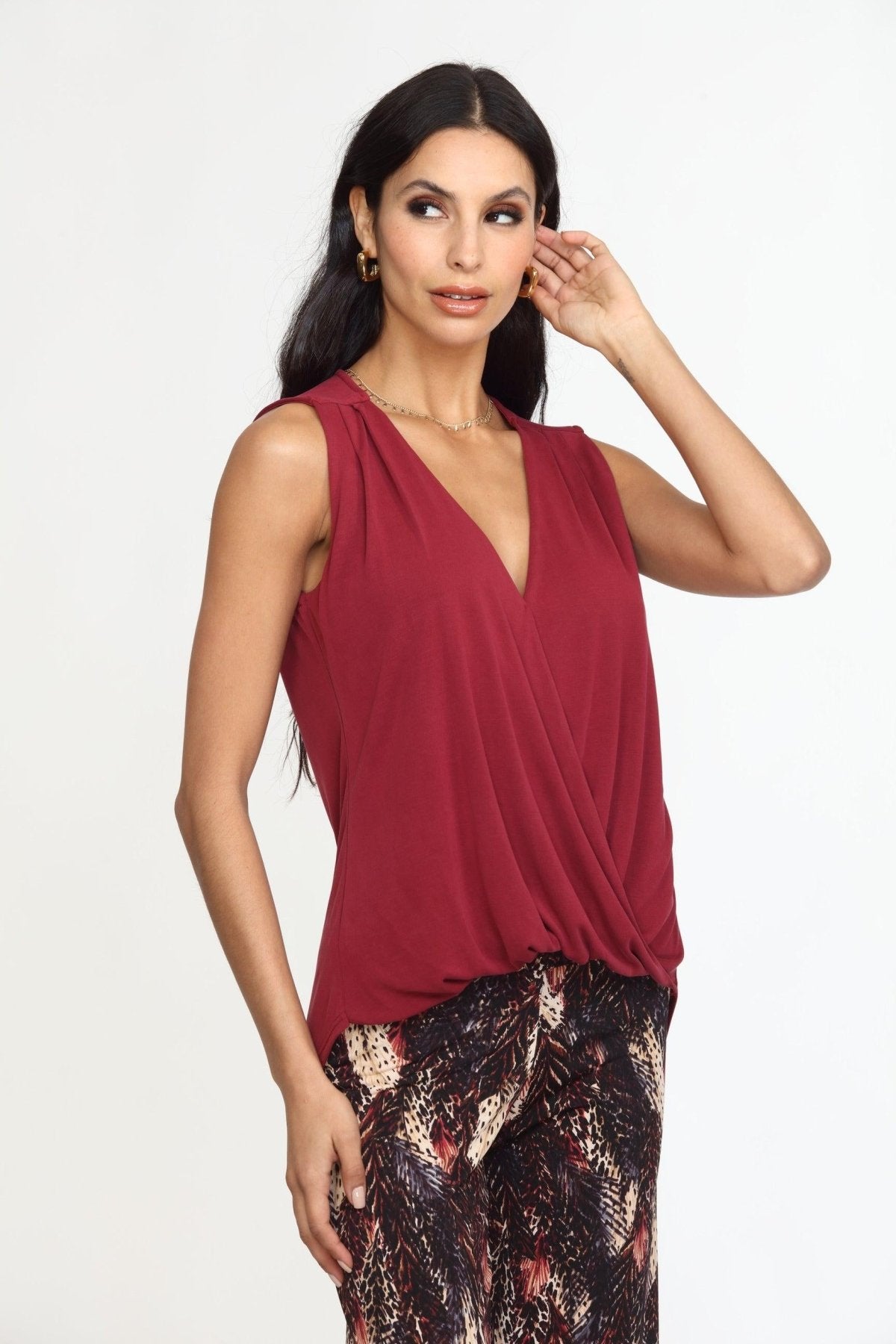 sleeveless burgundy top on woman in multicolored pants