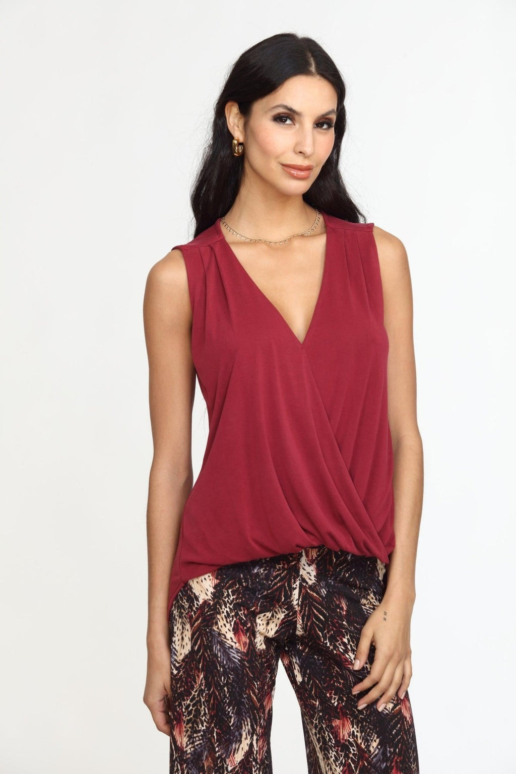 sleeveless burgundy top on woman in multicolored pants