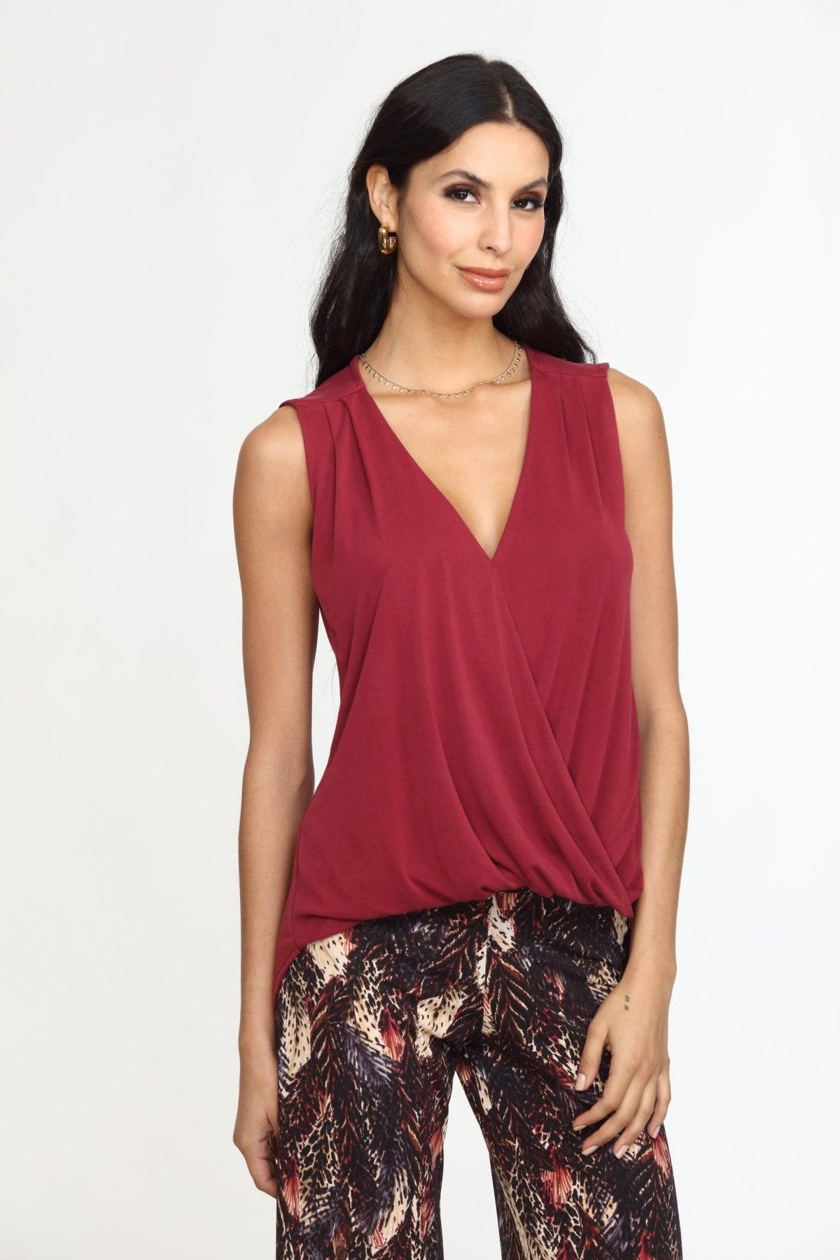 sleeveless burgundy top on woman in multicolored pants