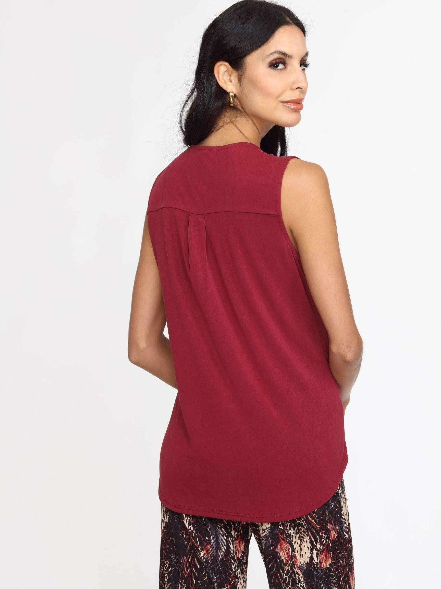 back side of sleeveless burgundy top on woman in multicolored pants