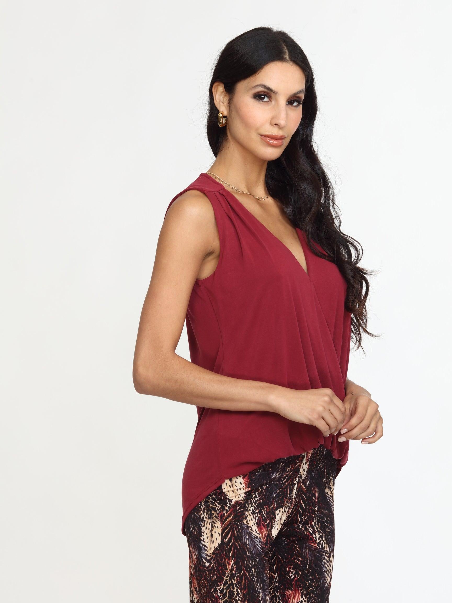 sleeveless burgundy top on woman in multicolored pants