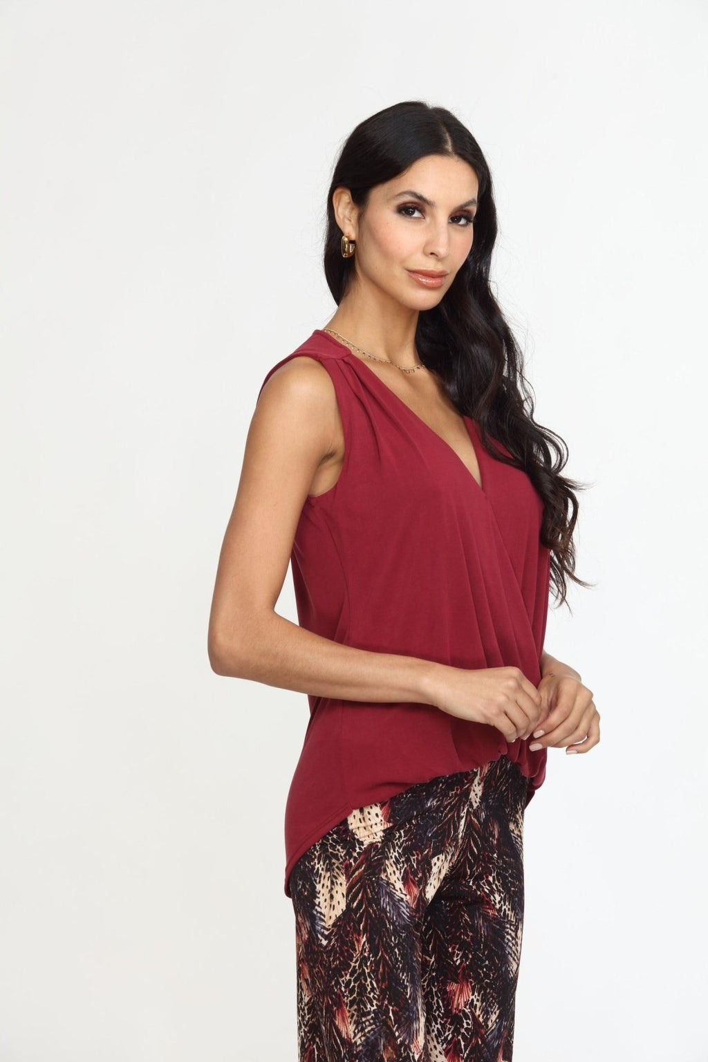 sleeveless burgundy top on woman in multicolored pants