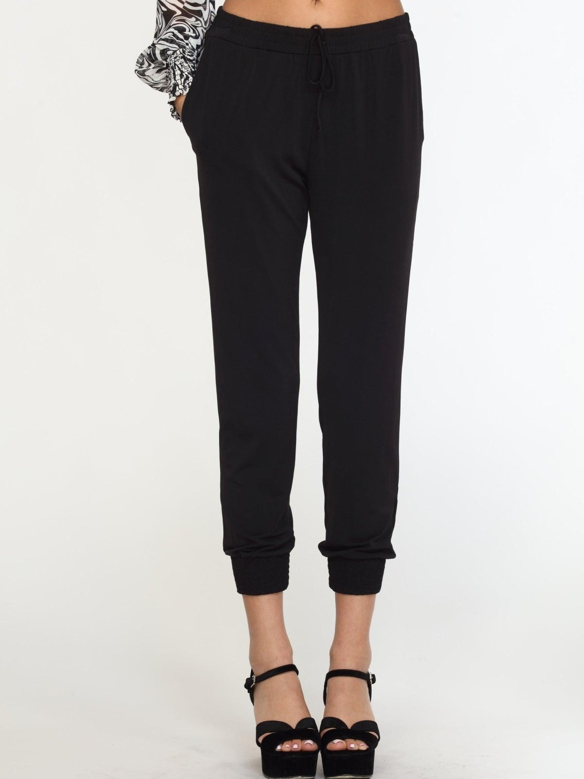 black tapered jogger pants on woman in black high heels